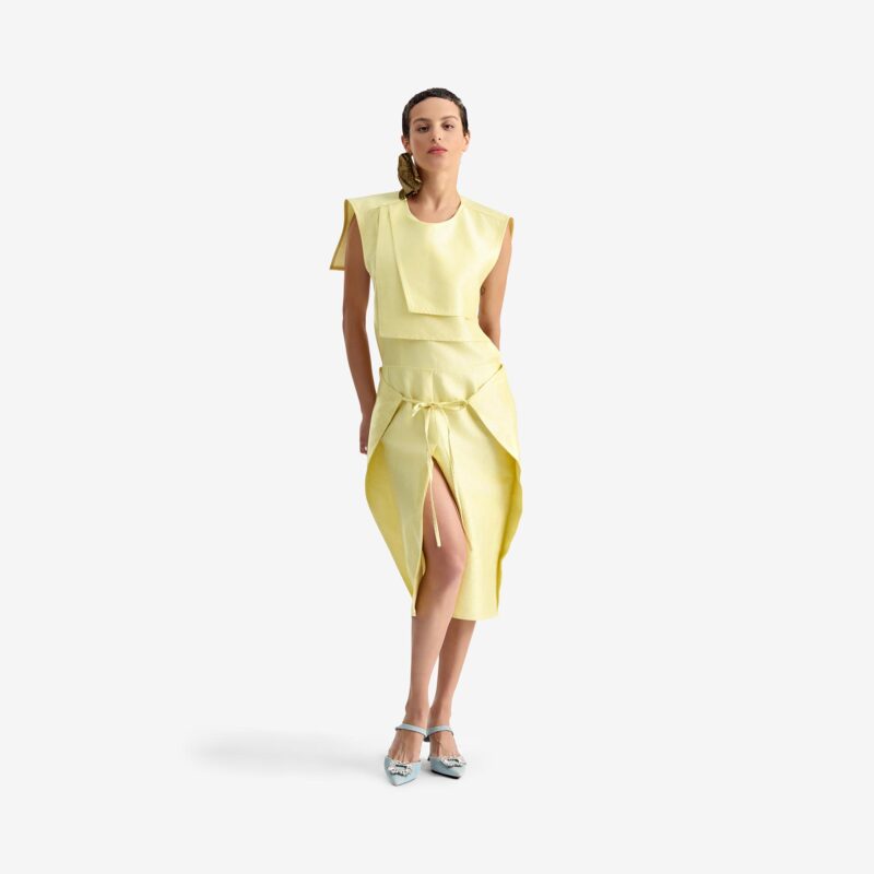 Caterpillar Dress Creamy yellow - This straight-cut midi dress features a clean silhouette with a round neckline and structured rectangular chest panels that add architectural depth.