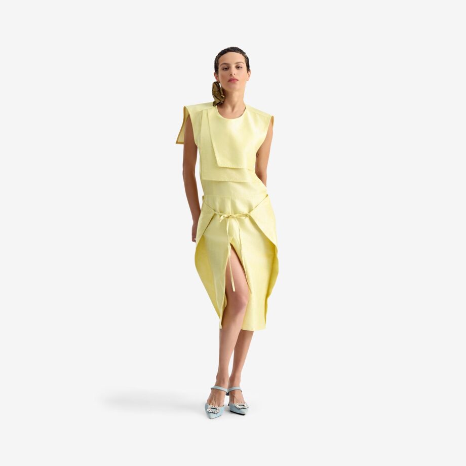 Caterpillar Dress Creamy yellow - This straight-cut midi dress features a clean silhouette with a round neckline and structured rectangular chest panels that add architectural depth.