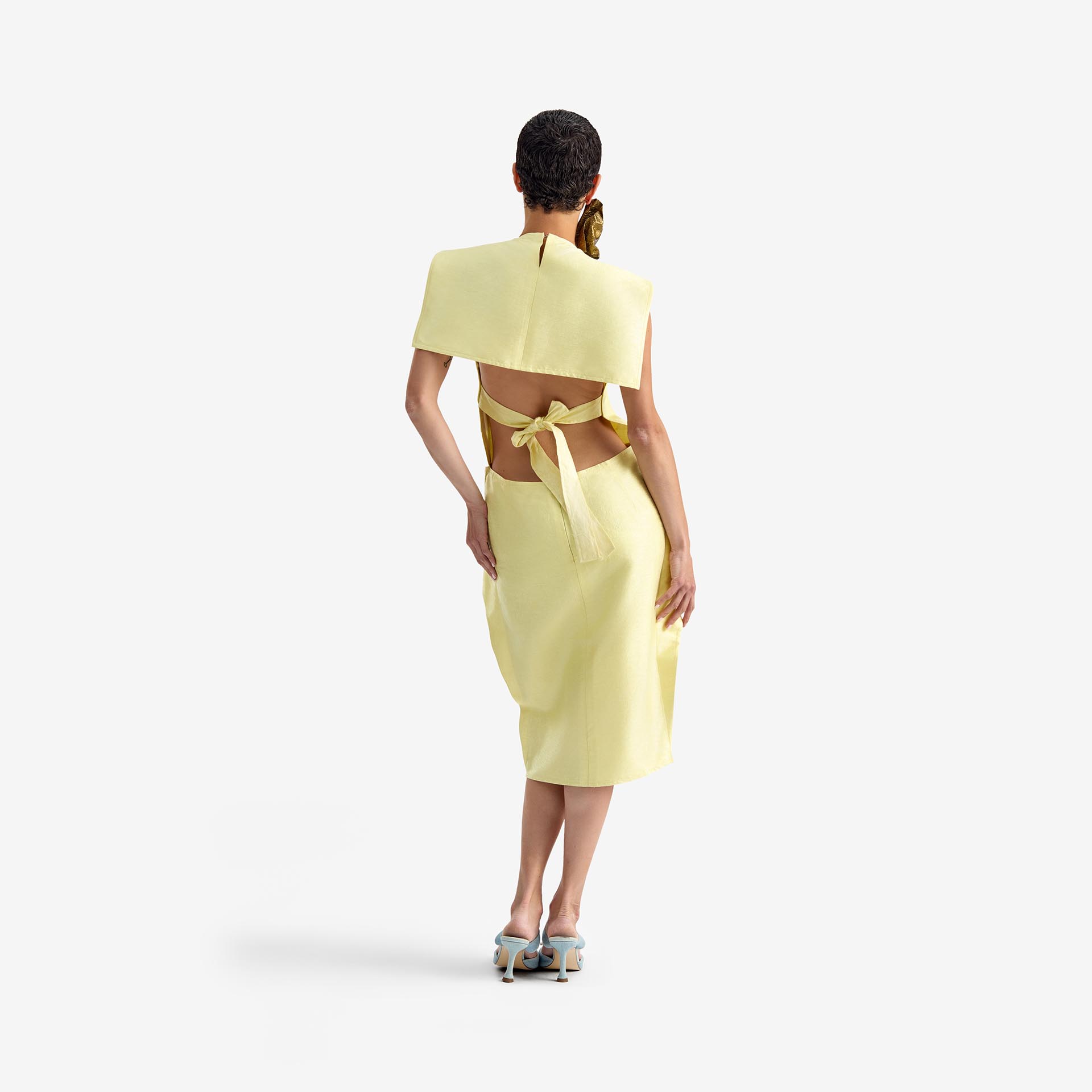 Caterpillar Dress Creamy yellow - This straight-cut midi dress features a clean silhouette with a round neckline and structured rectangular chest panels that add architectural depth.