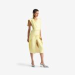 Caterpillar Dress Creamy yellow - This straight-cut midi dress features a clean silhouette with a round neckline and structured rectangular chest panels that add architectural depth.